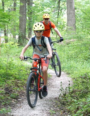                                Finn Banas and his father Jon hit the Bell Branch Loop trail at the now-opened Seven Mile Loop hiking and biking trail on June 19, 2020. The trails, located on the former property of the Northville Psychiatric Hospital grounds, were officially opened that day by Northville Township.