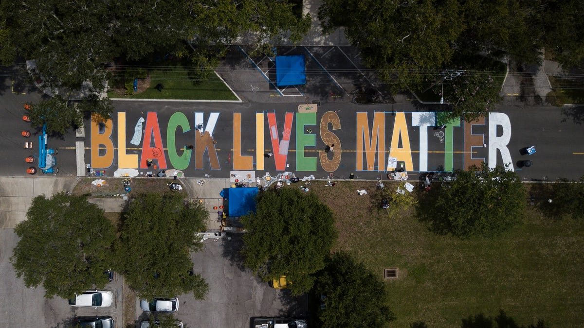 Local artists paint a Black Lives Matter street mural in front of the Dr. Carter G. Woodson African American Museum on Thursday in St. Petersburg, Florida. The mural will be ready when the city kicks of its Juneteenth celebrations on Friday morning.