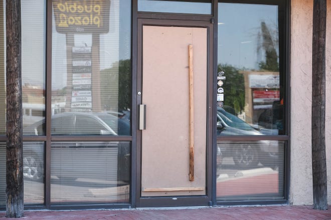 The glass door to Digital Solutions is boarded up after it was broken by an unknown person on Saturday, June 20, 2020.