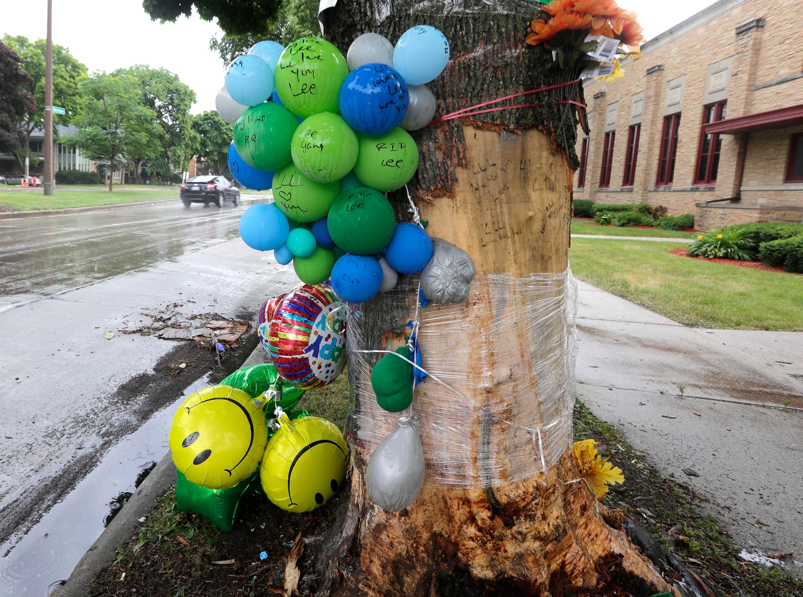 A memorial is seen on a tree where a 34-year-old woman died when the vehicle she was in lost control and hit a tree in the 3700 block of North Sherman Boulevard.