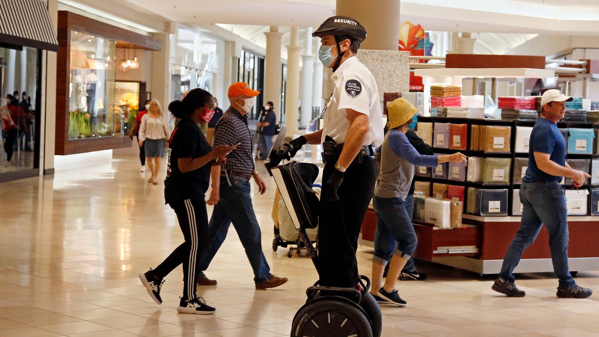 A security guard wearing a mask and riding a Segway patrols inside Penn Square Mall as the mall reopens in Oklahoma City in this May 1, 2020 file photo.
