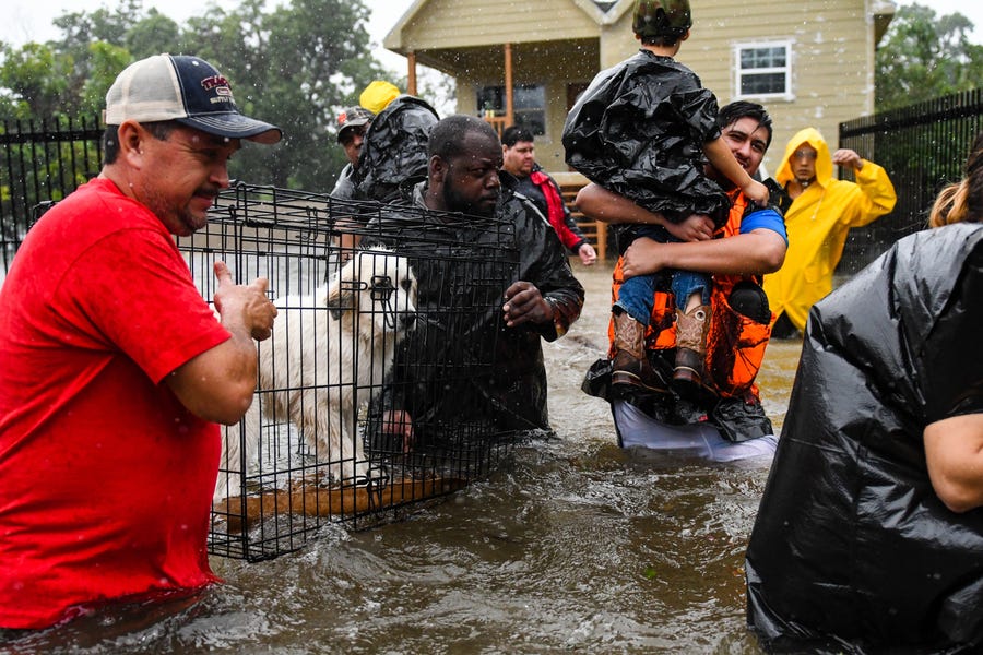Volunteers and first responders help flood victims evacuate to shelters as waters rise from Hurricane Harvey on Aug 28, 2017, in Houston.