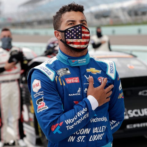 Driver Bubba Wallace stands for the national anthe