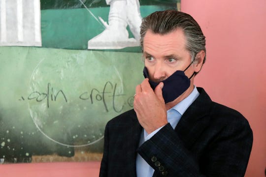 Gov. Gavin Newsom wears a protective mask on his face while speaking to reporters at Miss Ollie's restaurant during the coronavirus outbreak in Oakland, Calif., on June 9, 2020.