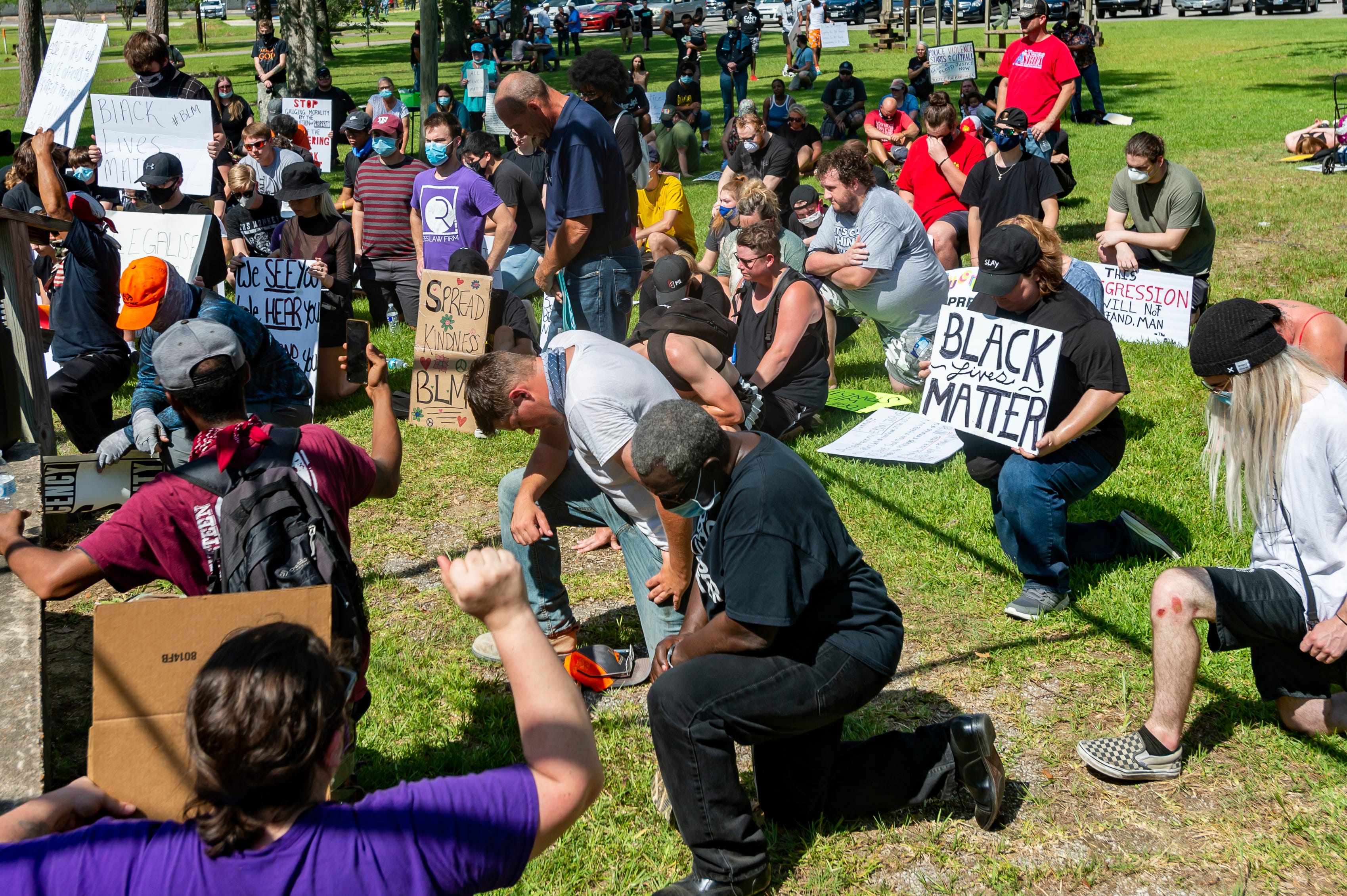 In a Saturday, June 6, 2020 photo, protesters observe an eight minute and forty-six second moment of silence in honor of George Floyd in Gould Park in Vidor, Texas. Several hundred people came out to the park on Saturday afternoon for a protest and peace march in honor of George Floyd who died while being detained by Minneapolis police. (Fran Ruchalski/The Beaumont Enterprise via AP)