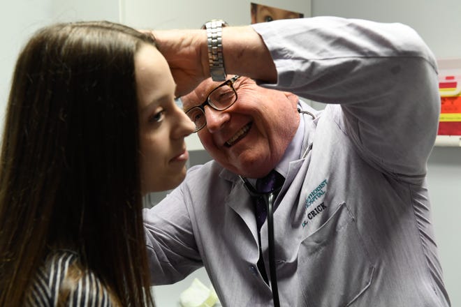 Dr. Larry Crick looks into Ashley Morris’ ears during a routine examine Thursday. The local pediatrician is retiring after 39 years, June 18, 2020.