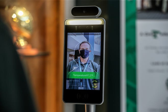 Trinity High School Principal Daniel Zoeller demonstrates one of four temperature readers inside of the school on Friday, June 26, 2020.