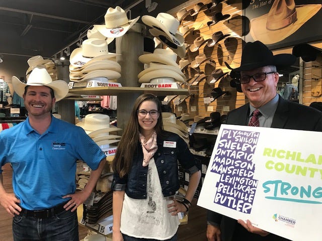 The Boot Barn at 833 Lexington-Springmill Road  in Ontario celebrated a grand opening and ribbon cutting with Chamber of Commerce officials Friday. At left, Richland County Commissioner Tony Vero is joined by Allison Stover, assistant store manager, and Ontario Mayor Randy Hutchinson. The local officials tried on some cowboys hats at the urging of media.