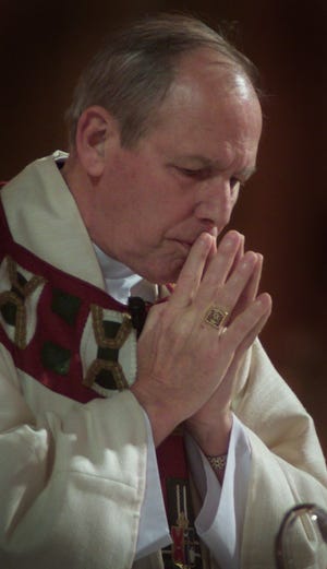 Bishop Matthew Clark prays during Thanksgiving Day Mass at Sacred Heart Cathedral on Thursday, Nov. 28, 2002.