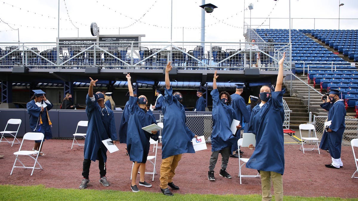 Binghamton High School seniors toss their caps in celebration after graduation on Sunday, June 28, 2020, at NYSEG Stadium in Binghamton.