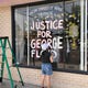 Crissy Burgstaler paints her storefront window with "Justice for George Floyd," May 31, 2020.