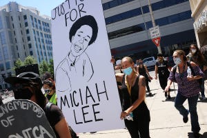 Miciah Lee's mother Susan Clopp carries a sign for her son during a Black Lives Matter rally in Reno on June 26, 2020.