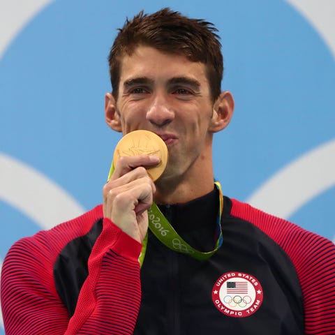 Michael Phelps kisses his gold medal after swimmin