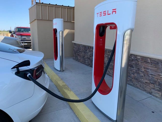 An electrically-powered automobile refuels at a Tesla charging station located at the 5R Travel Center in Deming, N.M., Wednesday, July 1, 2020.