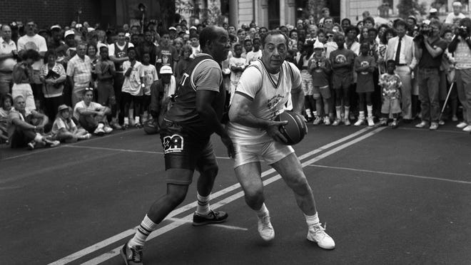 black and white photo of two men playing basketball