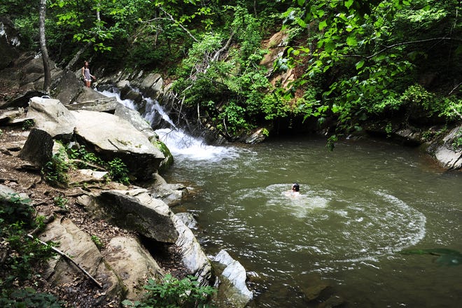The swimming hole can be accessed by hiking a trail for about 30 minutes from a parking lot off of Sugar Hollow Road behind the Charlottesville reservoir along the south fork of the Moorman's River.