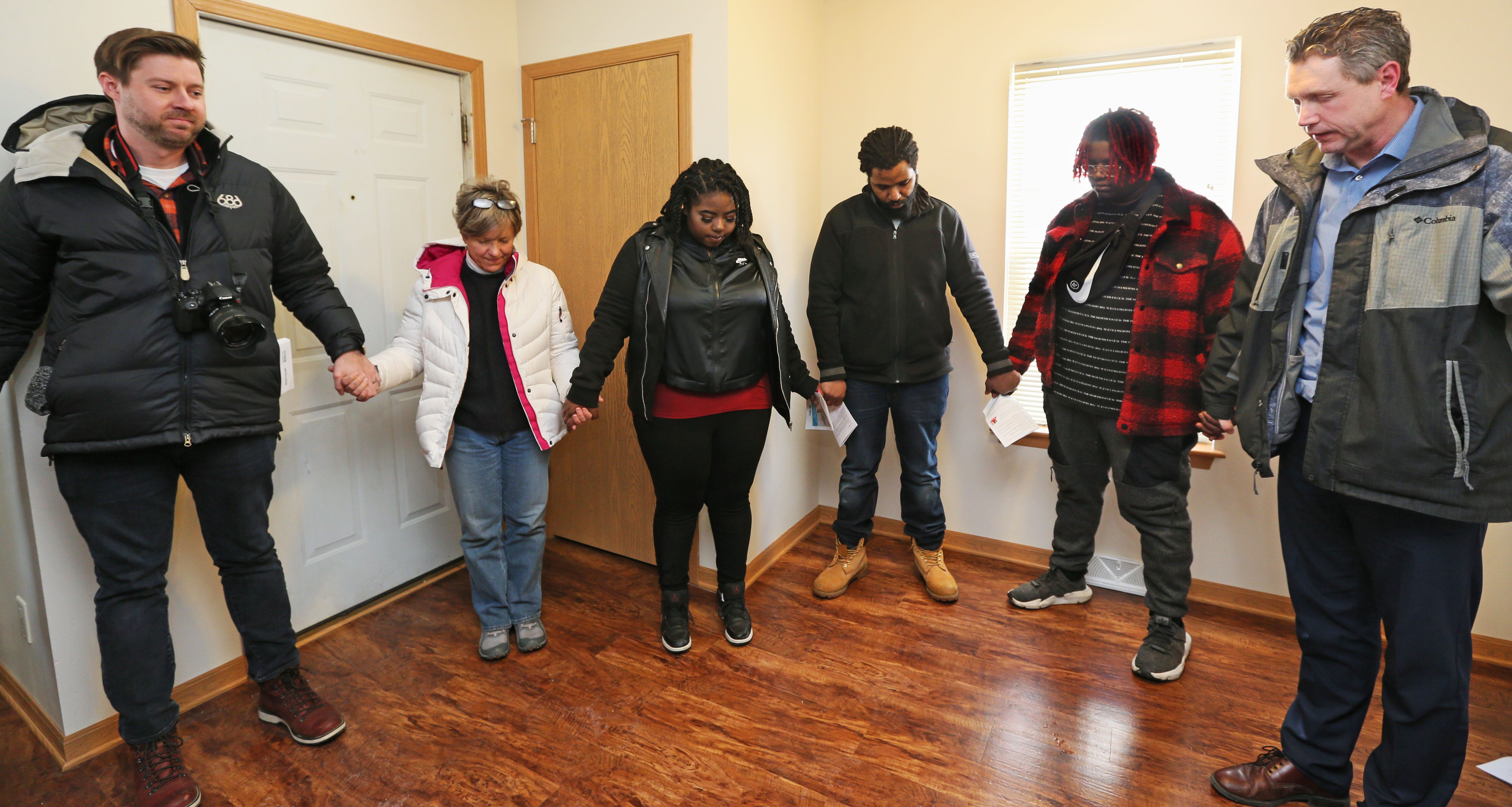 Brian Sonderman, right, Milwaukee Habitat for Humanity executive director, prays for Shema Mosely, third from left,  during her home dedication Feb. 20.