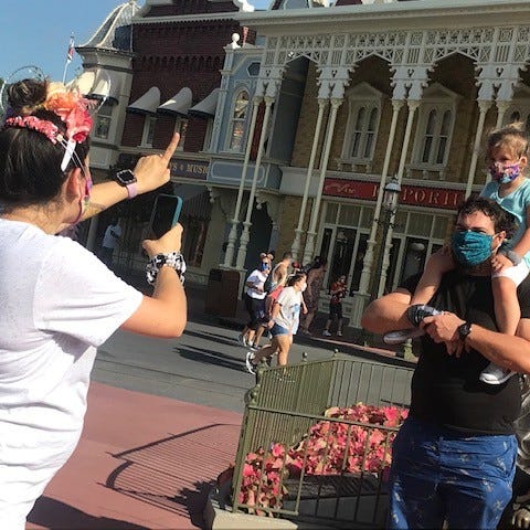 A family all wearing masks, stops for photos at Ma
