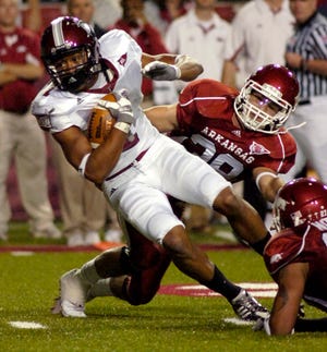 Troy wide receiver Cornelius Williams, left, tries to spin away from Arkansas safety Matt Harris after catching a pass in Fayetteville, Ark., Saturday, Nov. 14, 2009.