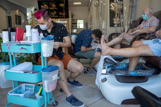 Sunshine Nails Salon owner Anthony Mai gives Lee Rolfe, 63, of Palm Springs a pedicure inside the salon in Palm Springs, Calif., on July 9, 2020. 