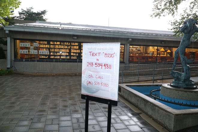                                The Farmington Community Library on Twelve Mile Road has instructions at its entrance for patrons to call a number so they can pick up materials they've reserved online.