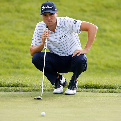 Justin Thomas eyes his putt on the 18th hole durin