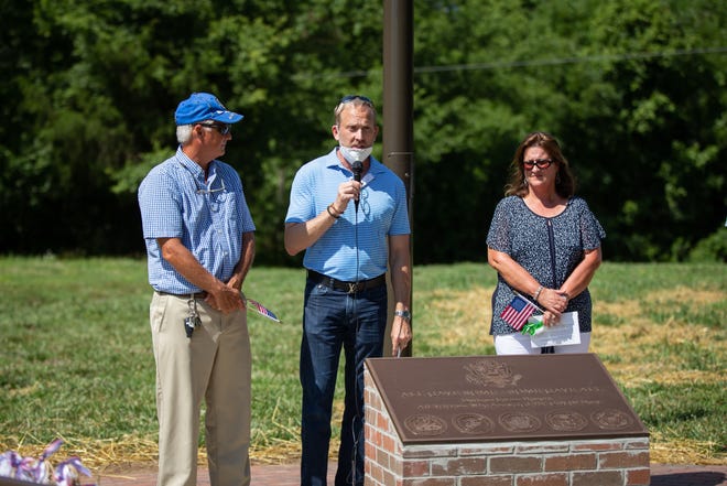 Ray Smith, land development manager for Freehold Communities; Bill Charles, president of the Durham Farms Board; and Karen Poynor dedicate Veterans Walk at Durham Farms in Hendersonville.