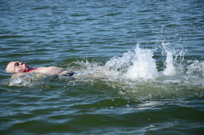 John Albright, 81, of Battle Creek, kicks the water on a backstroke as he swims the virtual 2020 Goguac Lake Swim on Monday.

Trace Christenson/The Enquirer