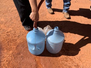 Larry Holiday delivers water by truck to a man whose home doesn't have running water in Monument Valley on the Navajo Nation.