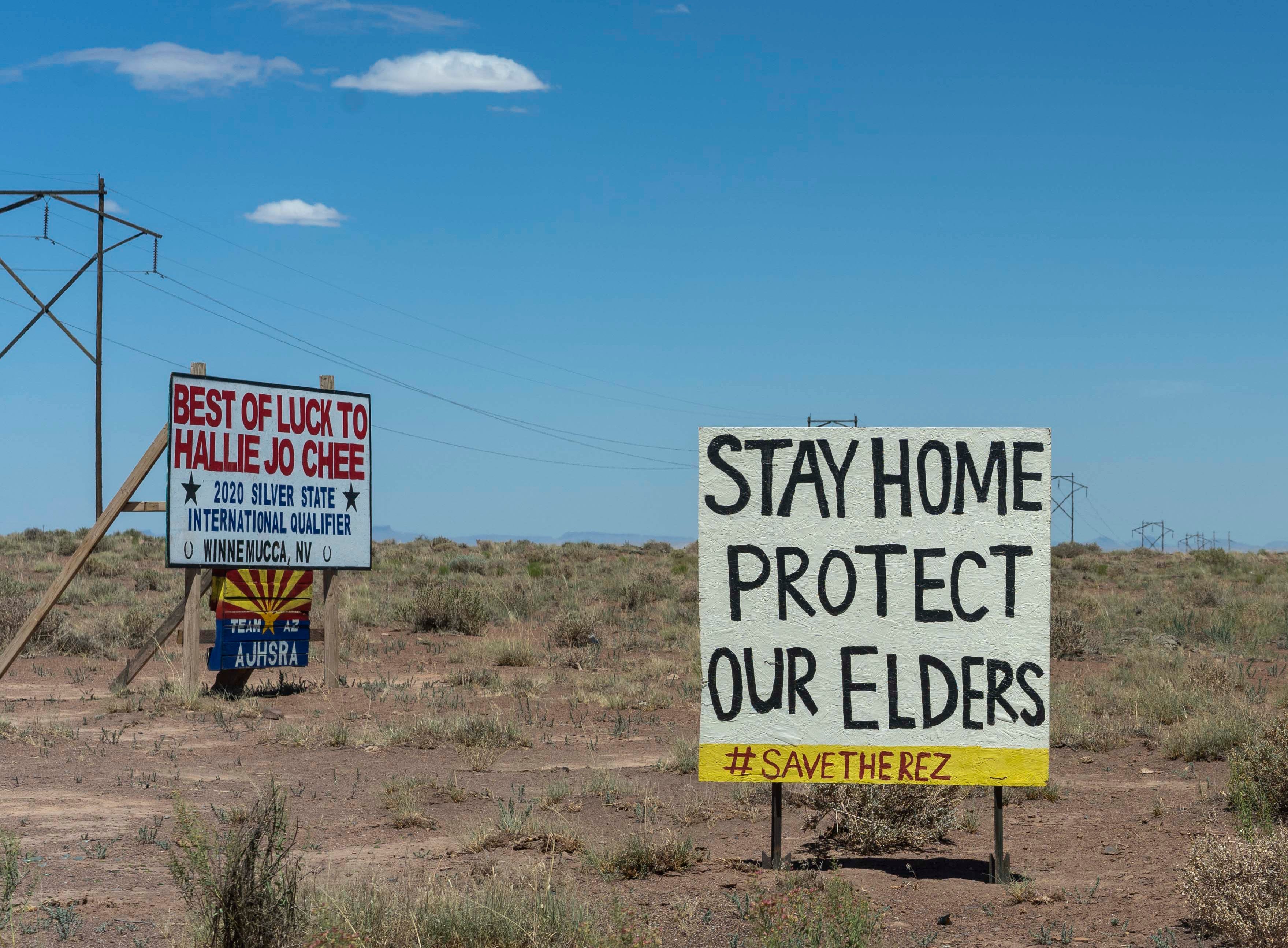 A sign next to a water-collection point in Leupp, Arizona, urges people to stay home to curb the spread of COVID-19. As older residents on the Navajo Nation have tried to stay isolated at home, relatives and community members have stepped in to haul water for them.