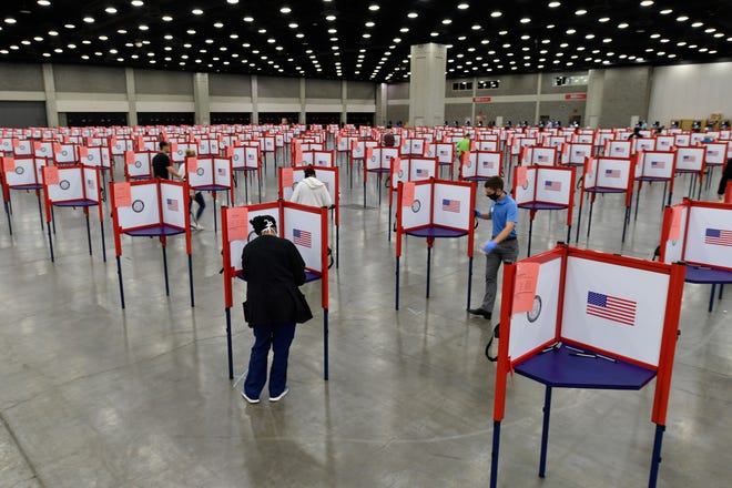 FILE - In this June 23, 2020, file photo voting stations are set up in the South Wing of the Kentucky Exposition Center for voters to cast their ballot in the Kentucky primary in Louisville, Ky. The November election is coming with a big price tag as America faces the coronavirus pandemic. The demand for mail-in ballots is surging, election workers are in need of training and polling booths might have to be outfitted with protective shields. (AP Photo/Timothy D. Easley, File)