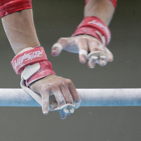 A gymnast's hands on the uneven parallel bars.