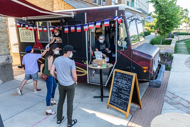 Le Reve Patisserie & Cafe serves customers from the restaurant's food truck at Root Common Park in Wauwatosa on Monday, July 13.