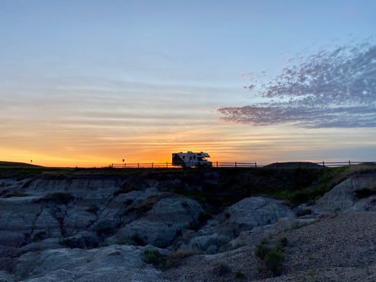 Our RV is parked as the sun rises in Badlands National Park.
