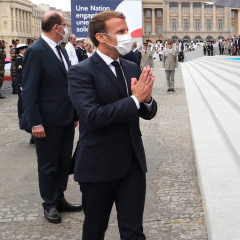 TOPSHOT - French President Emmanuel Macron greets 