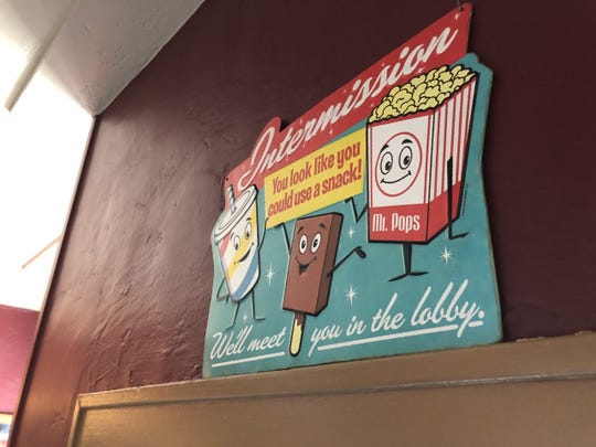 An old fashioned sign urging customers to buy snacks during intermission above the door inside the Sun Theatre in Grand Ledge on Monday, July 13, 2020. The theater has been closed since mid-March.
