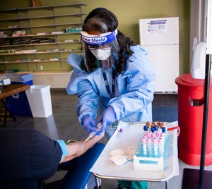 Southwest College of Naturopathic Medicine lab technician Beverly McCall takes a sample of blood from a COVID-19 clinical study participant.