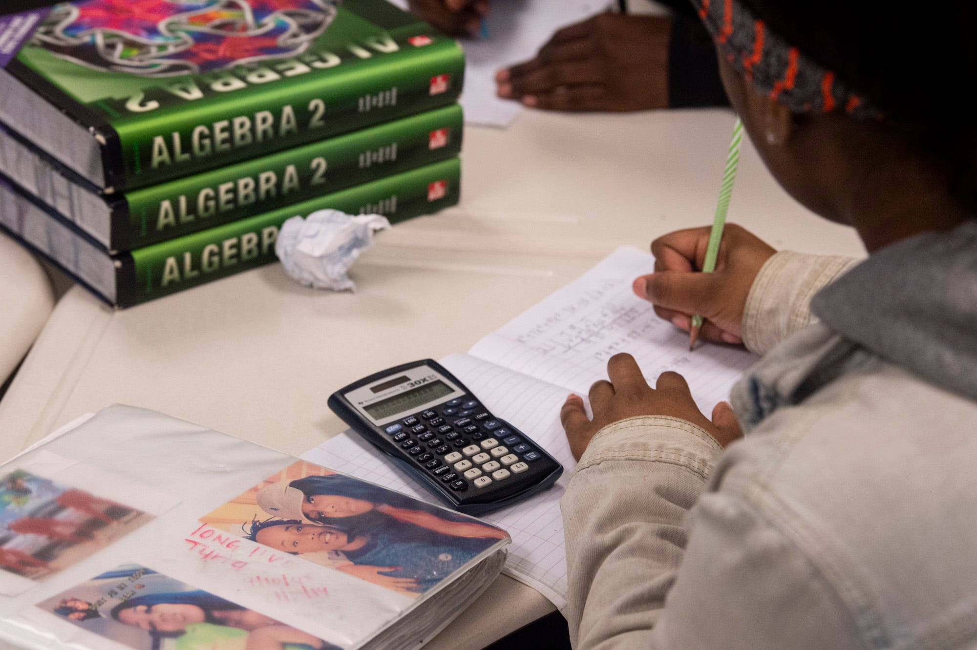 Helen Brown has a photos of her boyfriend, Ty'Riq Moon, on her binder as she takes notes in class at Carver High School in Montgomery, Ala., on Tuesday, Feb. 25, 2020. Moon was shot and killed at the Madison Ave. McDonalds in September 2019.