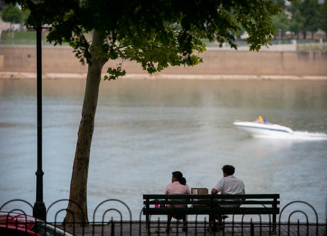 A couple eats together along Riverside Dr., in Covington, on Friday, July 17. A new plan calls for improvements to the waterfront in Ohio, Kentucky and 13 other states by 2030.