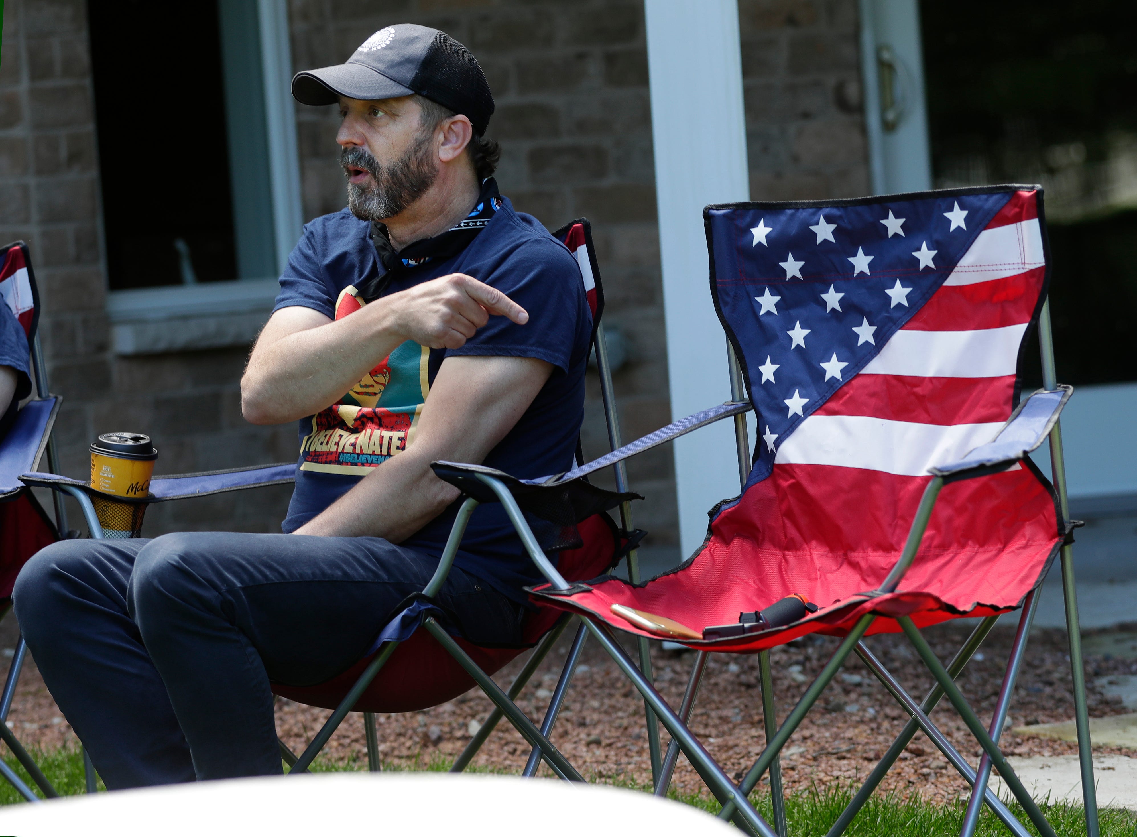 Aaron Lindstrom points to an empty chair in his parents' backyard in Hobart, Wis. on June 6, 2020, while saying his brother, Nate, could have been sitting there. Nate Lindstrom, 45, said three priests sexually abused him as a teen; he died by suicide in March 2020.