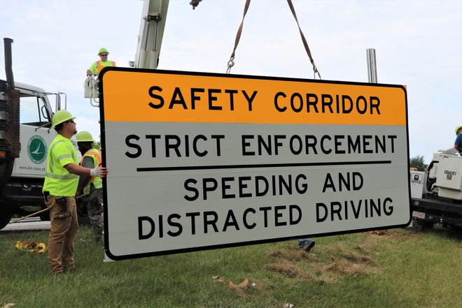 Ohio Department of Transportation workers install new signs along the eastbound lanes of US 33, designating 12 miles of the highway within Fairfield County as a distracted driving safety corridor. The project is a partnership between ODOT and the Ohio State Highway Patrol.