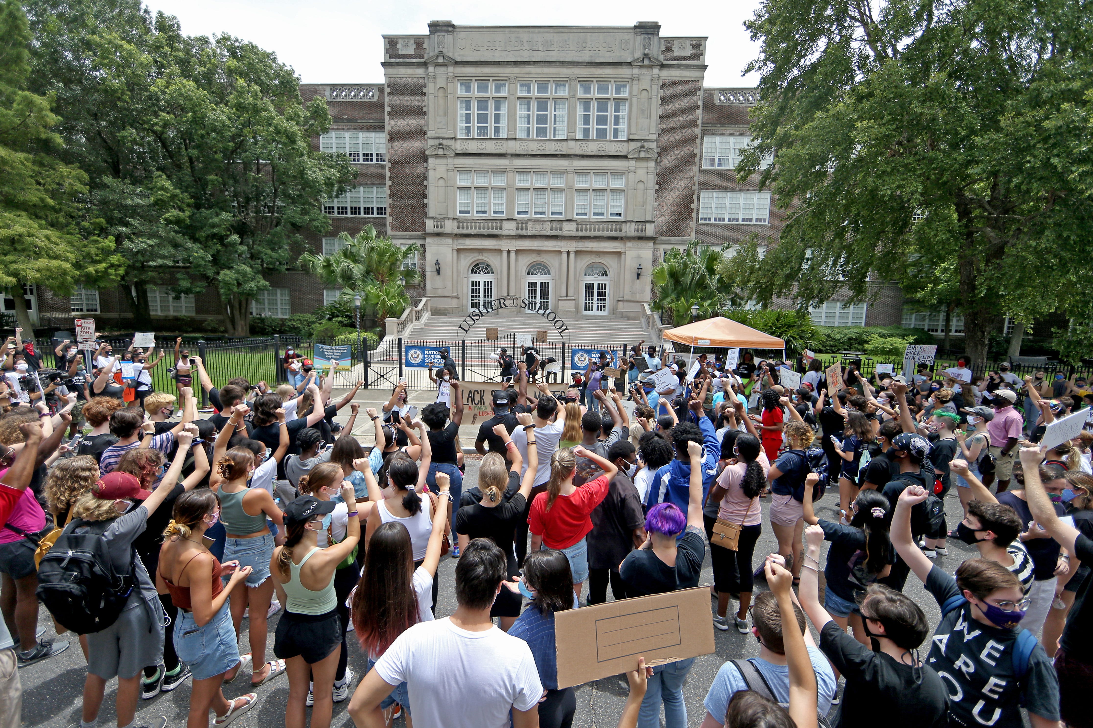 People rally in front of the high school to protest the name of the two educational institutions that comprise Lusher Charter School on July 4 in New Orleans. Protesters, including many current and former students, demanded the Orleans Parish School Board change the name of the charter schools, which honors staunch segregationist Robert Mills Lusher, who advocated using public education to advance white supremacy while serving as the Louisiana superintendent of education after the Civil War, during which he worked as a tax collector for the Confederacy.