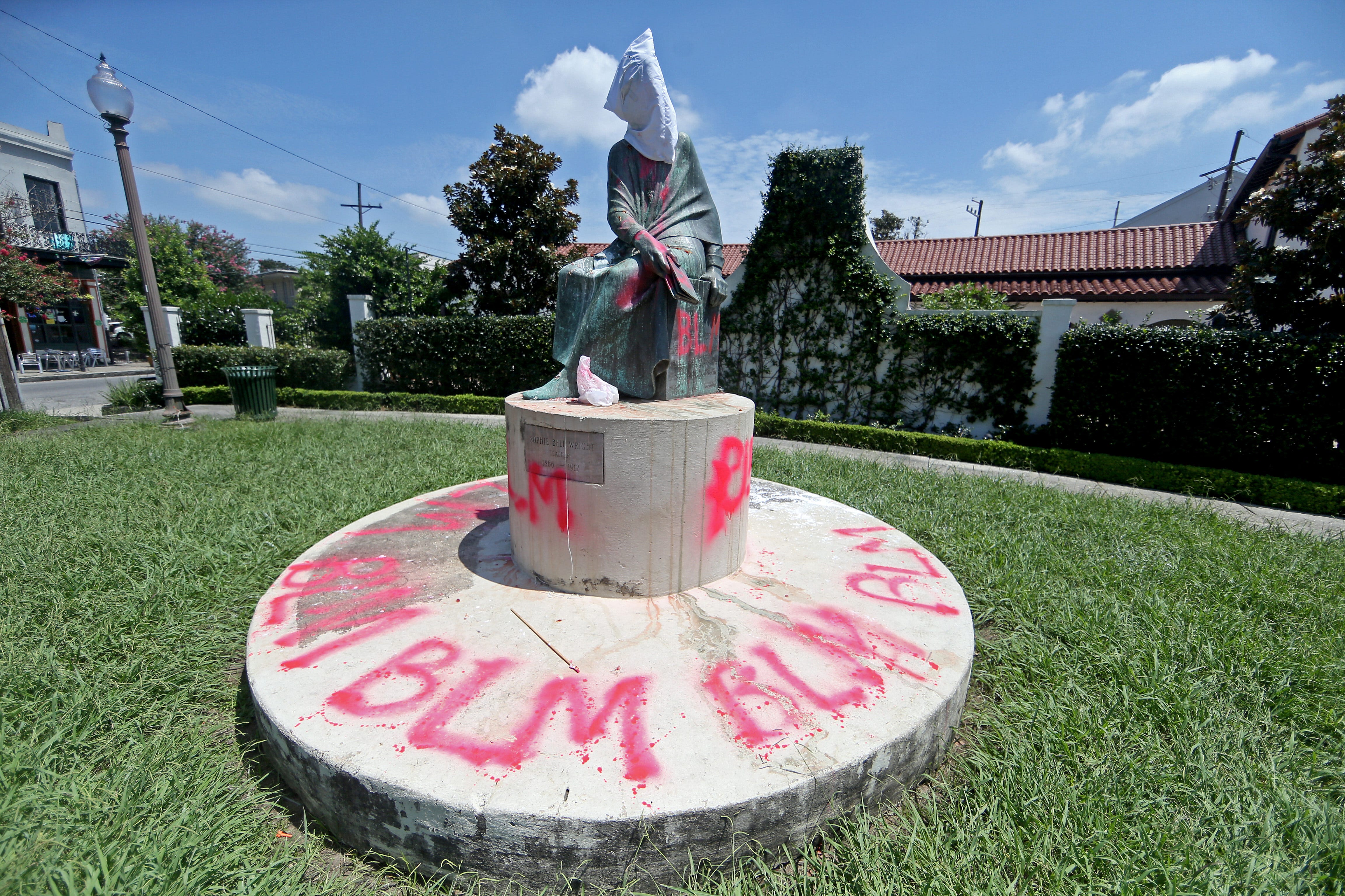 The statue of educator Sophie Bell Wright, whose father served in the Confederate Navy and Army, is covered with a white hood and spray-painted with the letters BLM on July 10 in New Orleans. The statue was one of many throughout New Orleans that protesters say celebrate white supremacy.