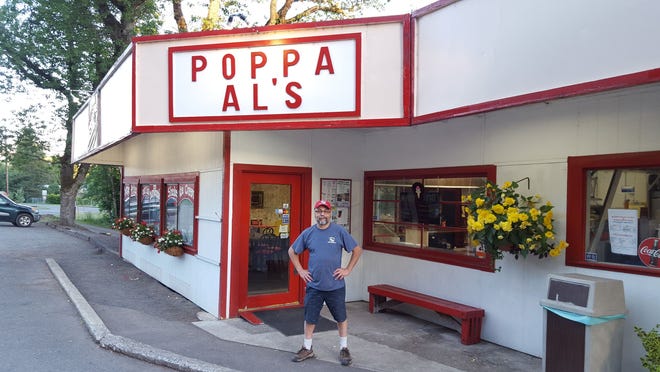 Owner Kevin Muniz stands in front of Poppa Al's Famous Hamburgers in Mill City, Oregon.