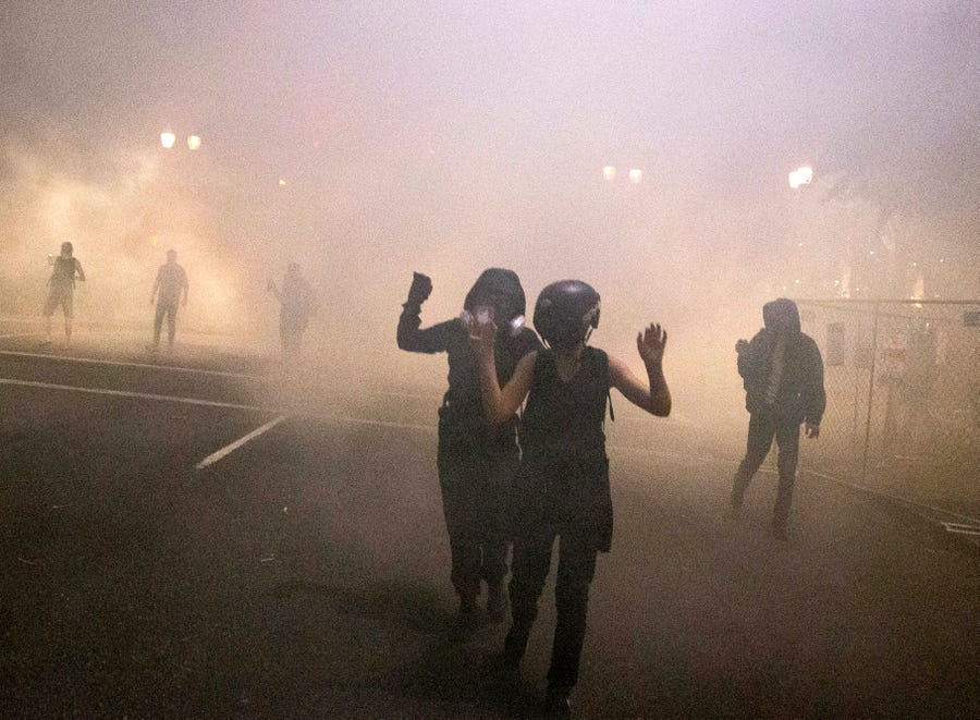 Protesters gather during a demonstration in Portland, Oregon, Thursday, July 16, 2020.  Federal officers deployed tear gas and fired less-lethal rounds into a crowd of protesters late Thursday.  The actions came just hours after the head of the Department of Homeland Security called the protesters 