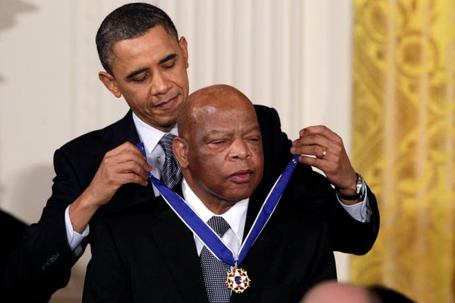 FILE - In this Feb. 15, 2011, file photo, President Barack Obama presents a 2010 Presidential Medal of Freedom to U.S. Rep. John Lewis, D-Ga., during a ceremony in the East Room of the White House in Washington. Lewis, who carried the struggle against racial discrimination from Southern battlegrounds of the 1960s to the halls of Congress, died Friday, July 17, 2020. (AP Photo/Carolyn Kaster, File)