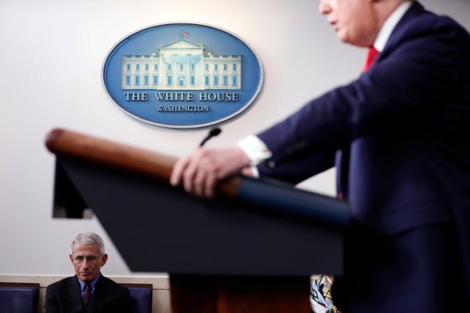 FILE - In this April 9, 2020, file photo Dr. Anthony Fauci, director of the National Institute of Allergy and Infectious Diseases, listens as President Donald Trump speaks about the coronavirus in the James Brady Press Briefing Room of the White House in Washington. (AP Photo/Andrew Harnik, File)
