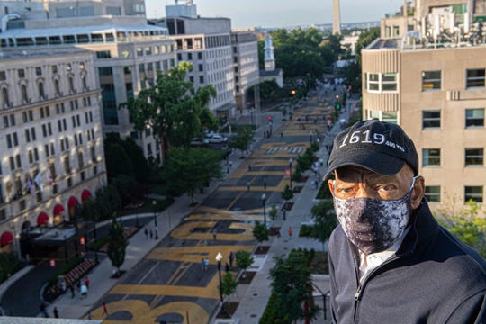 Rep. John Lewis, in a 1619 hat marking the start of U.S. slavery, looks over Black Lives Matter Plaza in Washington, D.C., on June 7, 2020.