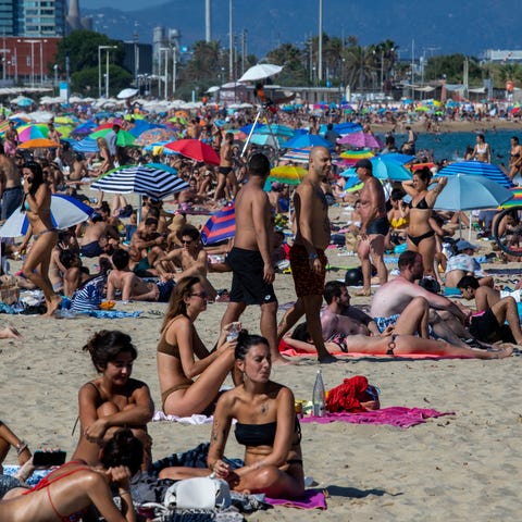 People enjoy the beach in Barcelona, Spain, Saturd