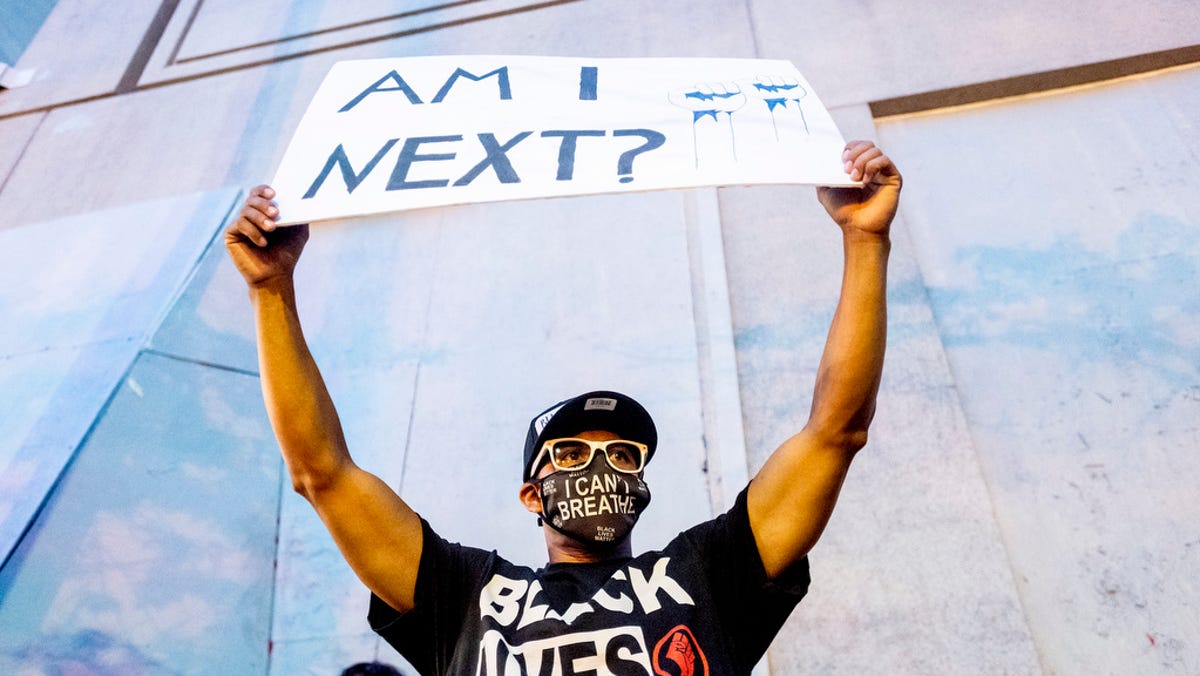 Romeo Ceasar holds a sign during a Black Lives Matter protester on Monday, July 20, 2020, in Portland, Oregon.